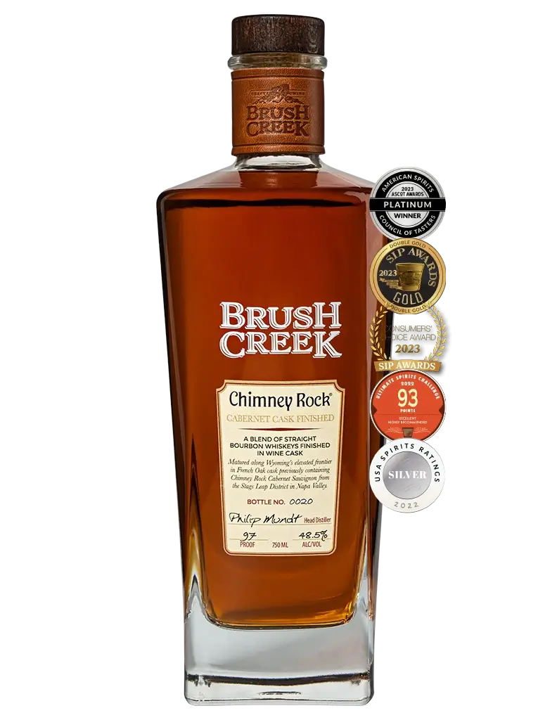 Bottle of Brush Creek Chimney Rock Cabernet Cask Finished Straight Bourbon Whiskey with awards to the right of the bottle