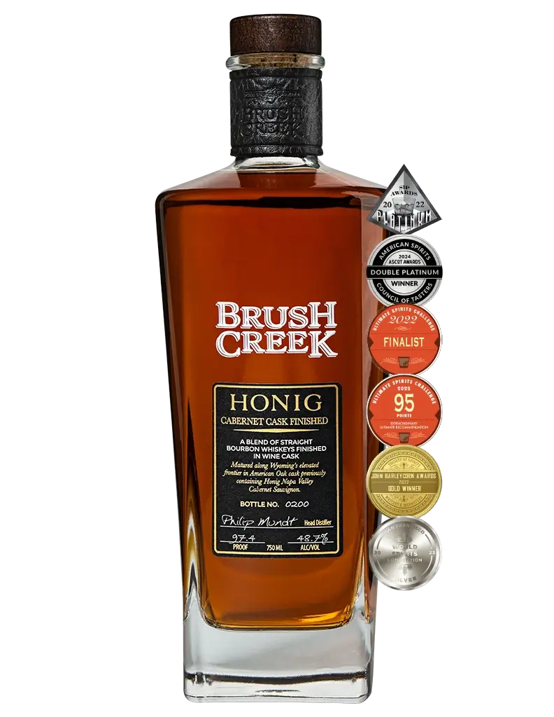 Bottle of Brush Creek Honig Whiskey - Cabernet Cask Finished with awards listed to the right of the bottle